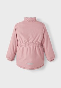 Giacca imbottita rosa con colletto alto, vita elastica e dettagli con bottoni dorati. Presenta maniche lunghe e un dettaglio in tessuto riflettente sul retro.