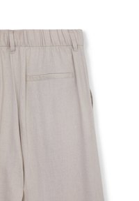 Pantaloni beige chiari con elastico in vita, dotati di una tasca posteriore singola e di un tessuto liscio e textured per comfort e stile.