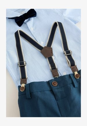 Camisa de botón azul claro con pajarita azul marina, pantalones azul marina y tirantes azul marina con bordes crema y detalles en cuero marrón.