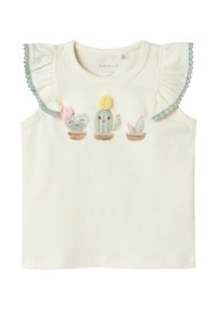 Biała bezrękawnikowa bluzka z falbankami na ramionach, z haftowanymi kaktusami w doniczkach, ozdobiona pastelowymi kolorami i teksturowymi detalami.