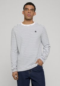 Gestreept shirt met lange mouwen in wit en marineblauw, met een ronde halslijn en een klein logo op de linkerborst. Zachte katoenen stof.