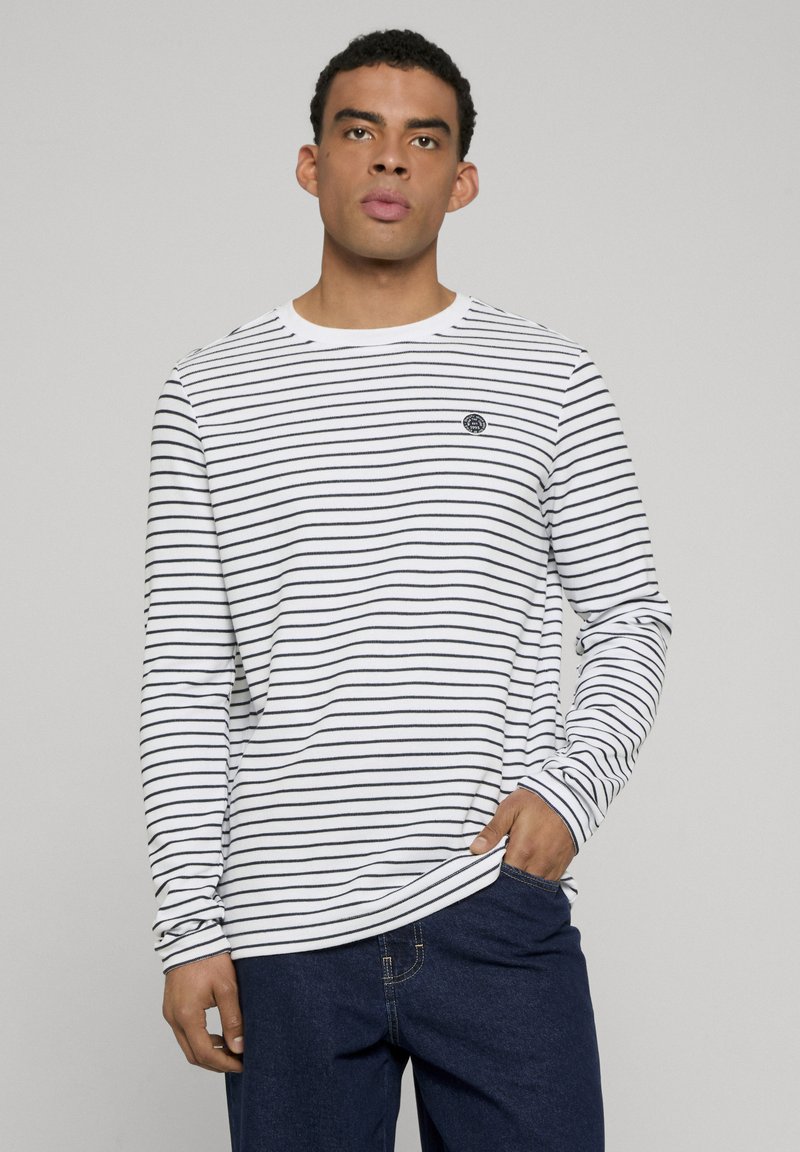 Gestreept shirt met lange mouwen in wit en marineblauw, met een ronde halslijn en een klein logo op de linkerborst. Zachte katoenen stof.