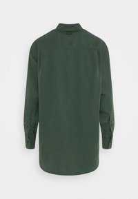 Dlhý rukáv na košeli v tmavo zelenej farbe, vyrobený z hladkej látky, s ostrým golierom a zapínaním na gombíky na manžetách, s rovný strih a zaobleným lemom.