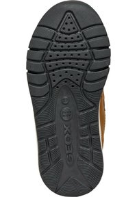 Suela de zapatilla de goma negra con textura en el dibujo, que incluye agujeros de ventilación, marca y elementos de diseño ergonómico para una mejor adherencia.