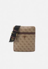 Bruine crossbodytas met patroon, donkere bruine horizontale streep, zwarte verstelbare riem en een driehoekig Guess-logo middenvoor.