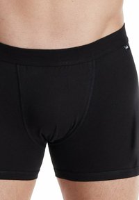 Svarta bomullskalsonger med en figurnära design, elastisk midja och slät textur med minimala sömmar för komfort.