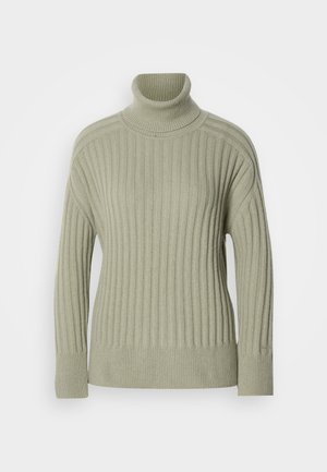 Maglione a collo alto verde chiaro realizzato in tessuto a costine. Design con spalle scese, dettagli cucitura minimal e maniche lunghe.