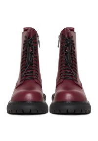 Bocanci de gleznă din piele burgundy cu șireturi negre, accente cu fermoar și o talpă chunky din cauciuc negru, cu un model texturat.