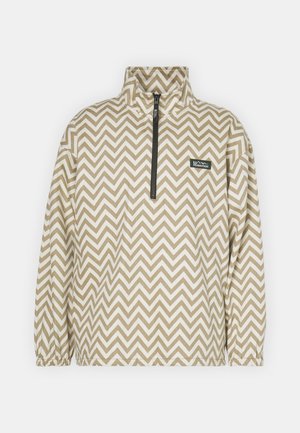 Bež pulover jakna s chevron vzorcem v rjavi in beli barvi, z visokim ovratnikom, četrtinskim zadrgo in elastičnimi manšetami.