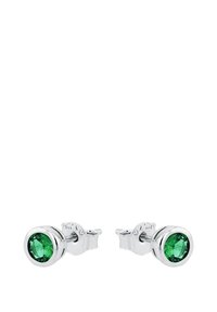Silver studs med runda gröna ädelstenar i bezelinställningar, visade mot en vit bakgrund.
