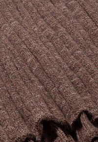 Braunes Strickgewebe mit einer gerippten Textur, das eine Mischung aus hellen und dunklen Fasern aufweist. Weich und flexibel, fällt es sanft an den Rändern.