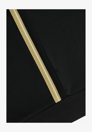 Tessuto nero con bordo verticale a righe beige e bianche e dettaglio orlo a costine lungo il bordo inferiore.