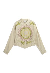 Camisa beige de manga larga y corta, con un cuello puntiagudo; presenta bordados circulares de sol y hoja en verde y rosa en la parte frontal.