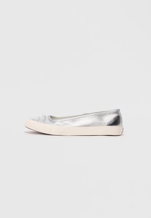 Zapato plano metálico plateado con punta redondeada, suela de goma beige y un pequeño lazo en la parte delantera. Textura suave y diseño minimalista.