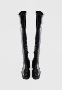 Black over-the-knee boots made of smooth leather with a chunky sole, featuring a sleek design and minimal seam detailing.