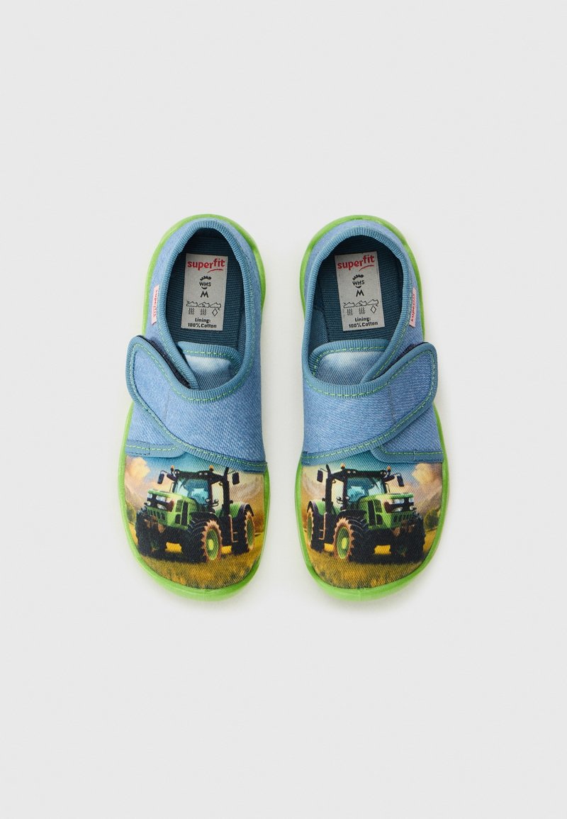 Paire de chaussures d’enfant bleues avec semelles vertes, présentant des impressions de tracteurs verts et des bandes Velcro, étiquetées avec des détails de doublure en coton.