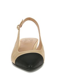 Beige en zwarte slingback platte schoen met een puntige neus. Glad materiaal met een contrasterende zwarte neuskap. Verstelbare enkelband met gouden hardware.