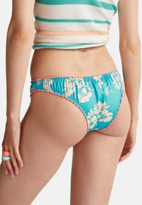 Modré květinové bikiny s elastickým pase s růžovými vlnitými okraji a hladkým, elastickým materiálem.