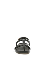 Zwarte leren sandalen met een platte zool, voorzien van een teenlus en meerdere dunne banden. Metallic hardwareaccenten zijn zichtbaar nabij de enkel.