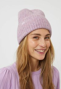 Gorro de punto rosa claro con textura acanalada y puño doblado. Presenta motas sutiles y un pequeño logo bordado en la parte delantera.