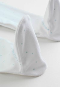 Calzini bianchi con una texture morbida caratterizzati da piccoli motivi a stelle blu. Il design include una punta arrotondata e bordi senza cuciture per il massimo comfort.