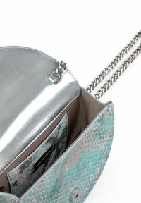 Bolso de mano con estampado de serpiente en plata metálica y turquesa, con una correa de cadena. Cuenta con un interior espacioso, un forro suave y un compartimento para tarjetas.