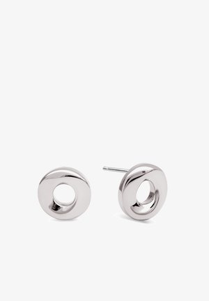 Paire de boucles d'oreilles clou circulaires en argent avec un centre creux et une finition lisse et polie sur fond blanc.