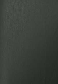 Matériau en cuir noir texturé avec un motif de grain fin, présentant une couleur sombre et uniforme ainsi qu'une surface lisse. Idéal pour le rembourrage ou les accessoires.