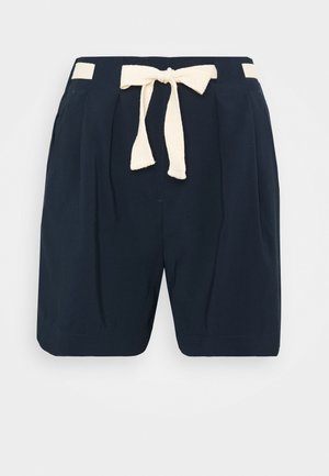 Bermudes bleu marine en tissu léger, avec une ceinture à nouer beige texturée, un devant plissé et des poches latérales.