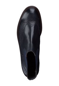 Bottine en cuir noir avec des détails de brogue, panneaux latéraux élastiques et semelle brun foncé. Texture lisse avec perforations décoratives.