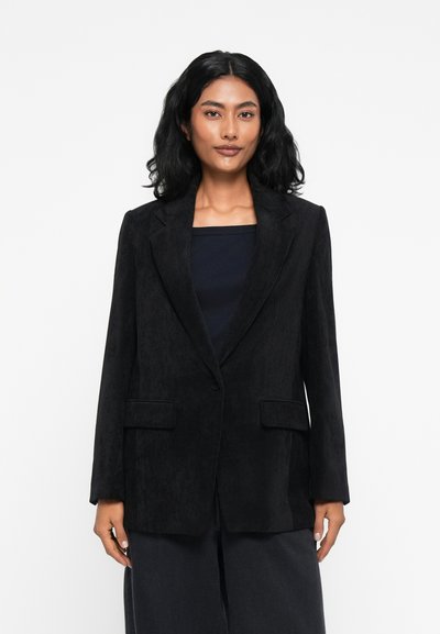 Blazer en velours côtelé noir avec un col à revers, fermeture à un bouton et deux poches avant. Tissu texturé et coupe décontractée.