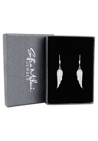 Söljdörhängen i vingform, prydda med små klara ädelstenar, visade i en grå, texturerad presentask klädd med svart tyg.