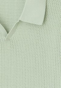 Pull en maille vert menthe clair avec un col en V et un col côtelé. La texture est respirante avec un motif vertical uniforme.