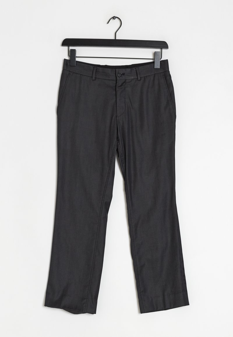 Černé kalhoty vystavené, s rovnými nohavicemi, jemně strukturovaným vzorem a zapínáním na knoflíky, zavěšené na černém ramínku.