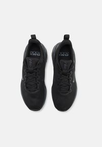 Sneaker sportive nere con tomaia in rete, punta rotonda, lacci e linguetta; presenta un marchio visibile e una suola in gomma testurizzata.