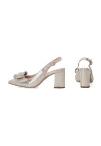 Sandały na obcasie typu slingback w metalicznej srebrnej, popękanej skórze, z noskiem w szpic i detalem w postaci kokardy. Wyróżniają się średnim, kwadratowym obcasem.