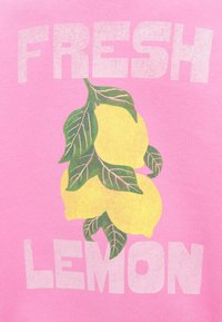 Ροζ μπλουζάκι με κίτρινα λεμόνια και πράσινα φύλλα, με τις λέξεις «FRESH LEMON» σε έντονα, υφή λευκά γράμματα.