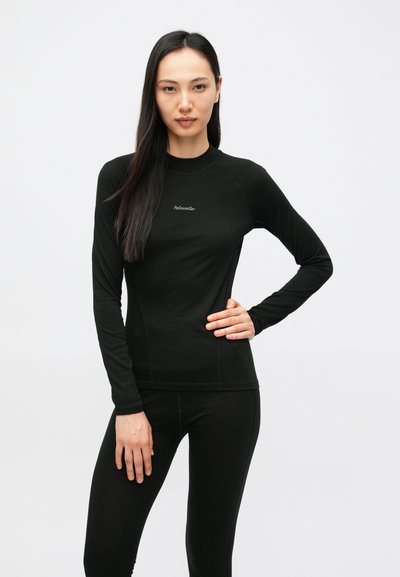 Bluză sport neagră cu mâneci lungi, decolteu rotund, textură fină și detaliu subtil cu logo pe piept. Asortată cu pantaloni negri.