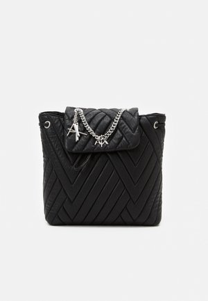 Bolso tipo cubo de cuero negro acolchado con solapa, cadena plateada y dijes de logo "A|X" plateados en el frente.