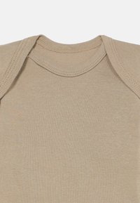 Beige kortermet body med ribbestruktur og rund hals; har mykt stoff og et enkelt, ugjort design.