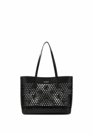 Zwarte Guess-tas met lange handvatten en ruitvormig uitsnijdingspatroon op het voorpaneel, met het merklogo in gouden letters.
