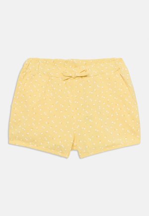 Pantaloni corti gialli con una trama morbida, dotati di un fiocco in vita e di un motivo di piccoli fiori bianchi. Progettati con tasche laterali.