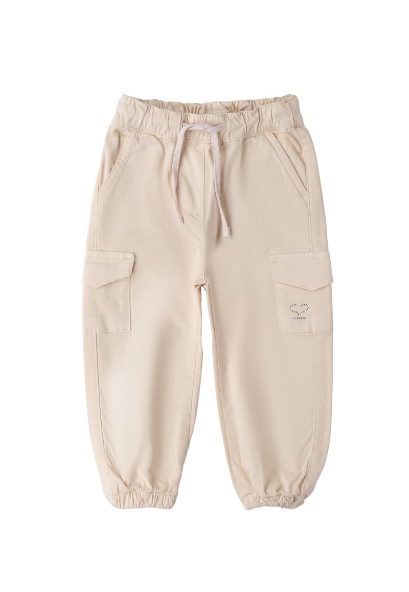 Beżowe spodnie cargo mają elastyczny pas z sznurkiem, dwie boczne kieszenie oraz elastyczne mankiety przy kostkach. Gładki materiał bawełniany.