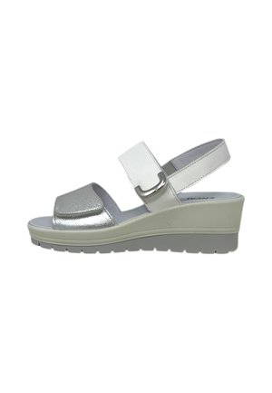 Sandalo con zeppa bianco e argento con punta aperta, cinturini regolabili e suola piatta bassa.