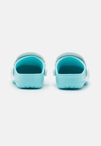 Blue and white clogs with a textured sole, open back, and adjustable heel strap; smooth interior with a light blue finish.