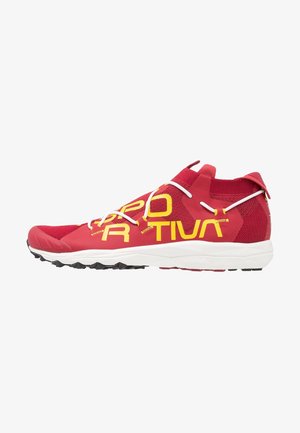 Zapato deportivo rojo con texto de logo amarillo, cordones blancos, cuello alto en el tobillo y suela negra con dibujo.