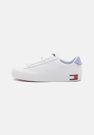 Hvid lavtop sneaker med hvide snørebånd, lysblå hælflap og Tommy Jeans-logo på ydersålen nær hælen.