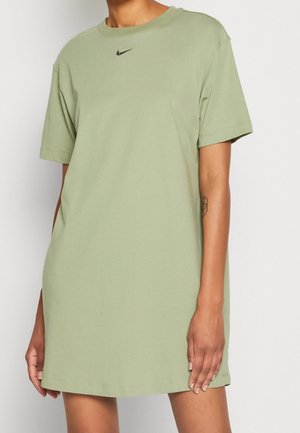 Olive green dress z t-shirtem Nike, krótkie rękawy, okrągły dekolt, luźny krój, z małym czarnym logo na klatce piersiowej i bocznymi rozcięciami.