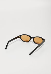 Mustad mustasilmad ovaalse raami ja pruuni toonitud läätsedega. Omavad stiilseid tempel, mille külgedel onDiskreetne logo. Ühtlane tekstuur kogu ulatuses.