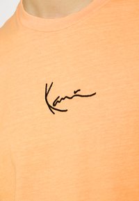 Karl Kani SMALL SIGNATURE WASHED TEE UNISEX - T-shirt estampada - light orange